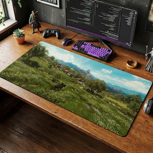 May include: A rectangular desk mat featuring a high-resolution landscape print of a lush green meadow with rolling hills, scattered trees, and a distant castle under a blue sky. The mat is positioned on a wooden desk surface with a computer setup.