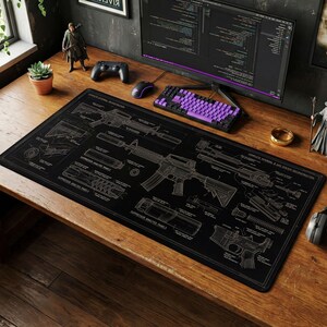 May include: A black desk mat featuring detailed schematics of a rifle. The design is in white, with various components labeled. A purple keyboard, mouse, and monitor are also visible on the wooden desk.