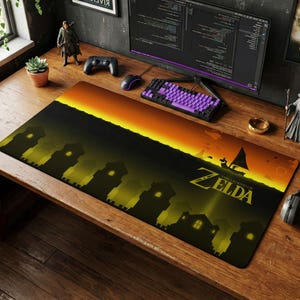 May include: A rectangular desk mat featuring a landscape illustration from The Legend of Zelda. The design displays a dark silhouette of a castle and buildings against a vibrant orange and yellow sunset sky, with a small sailboat on the horizon.