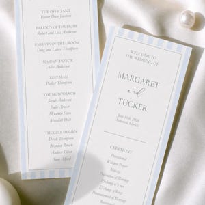 May include: Two rectangular wedding program cards featuring a light blue and white vertical striped border. The text includes 'The Wedding Party', 'Welcome to the Wedding of Margaret and Tucker', and a detailed ceremony schedule for June 16th, 2026.