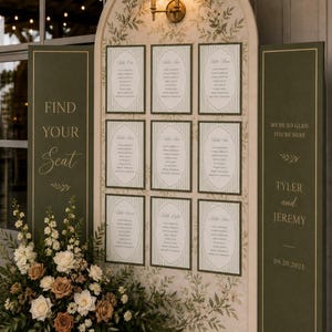 Puede incluir: Un panel de distribución de asientos para bodas en forma de arco con fondo crema e ilustraciones botánicas verdes. Incluye nueve tarjetas de mesa, paneles laterales con el texto "FIND YOUR SEAT" y "WE'RE SO GLAD YOU'RE HERE TYLER and JEREMY 09.20.2025", y un arreglo floral.