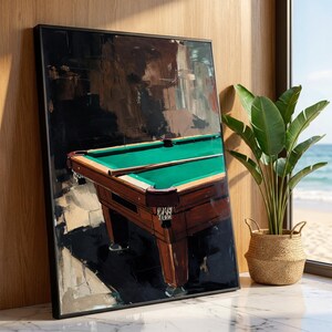 May include: A framed art print depicting a pool table. The artwork shows a green baize pool table with brown wooden detailing and legs. The background is a dark, abstract painting with brown and black hues. The print is displayed near a window.