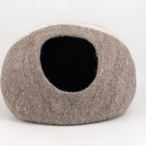 May include: A brown and white felt cat bed shaped like a dome with a round opening.