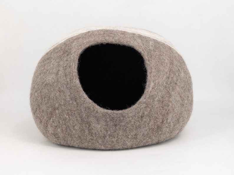 May include: A brown and white felt cat bed shaped like a dome with a round opening.