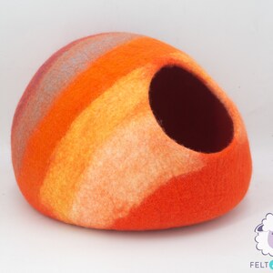 May include: Orange, yellow and white striped felt cat bed with a round opening. The bed is made of wool felt and is handmade.