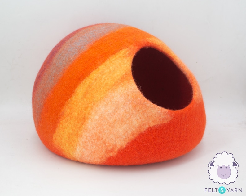 May include: Orange, yellow and white striped felt cat bed with a round opening. The bed is made of wool felt and is handmade.