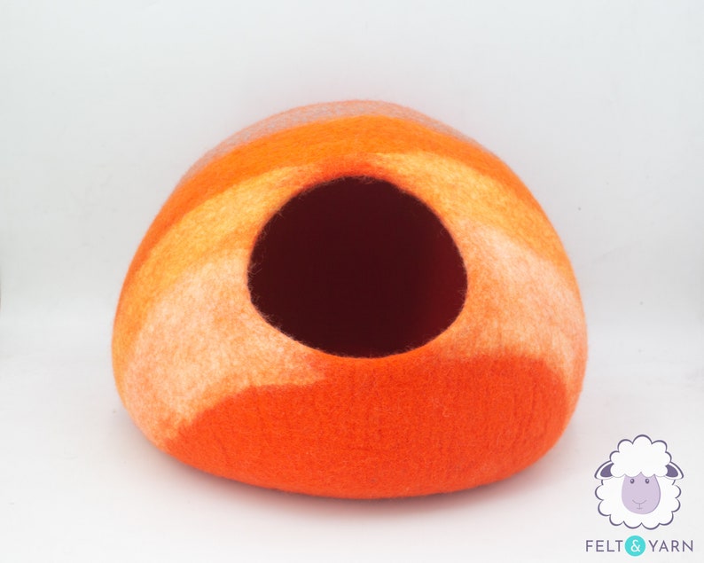 May include: Orange and white felted wool cat bed shaped like a dome with a round opening.