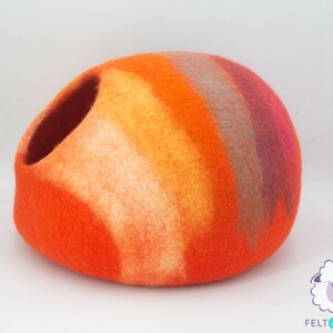 May include: Orange, yellow, pink and grey felt cat bed shaped like a dome with a round opening.