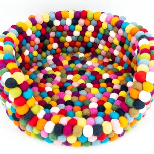 Pu&ograve; includere: Un letto rotondo per animali domestici colorato fatto di palline di feltro. Il letto &egrave; pieno di una variet&agrave; di colori, tra cui rosso, arancione, giallo, verde, blu, viola e bianco.
