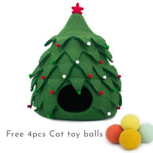 May include: A green felt cat bed shaped like a Christmas tree with red and white felt ornaments. The bed has a round opening for the cat to enter. Four colorful felt cat toy balls are included.