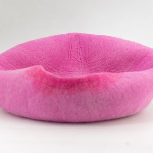 May include: A pink, fuzzy, round pet bed.