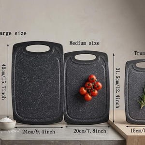 May include: Set of three dark gray cutting boards with a speckled pattern. The largest board is 40cm/15.7 inches long, the medium is 31.5cm/12.4 inches, and the smallest is 25cm/9.8 inches. The medium board has tomatoes, and the smallest has rosemary.