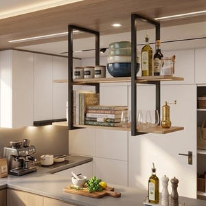 Puede incluir: Una cocina moderna con una estantería colgante. Las estanterías exhiben cuencos, tarros, libros y botellas de aceite y vinagre. Una cafetera y utensilios de cocina están en la encimera. La combinación de colores es neutra con acentos de madera y negro.