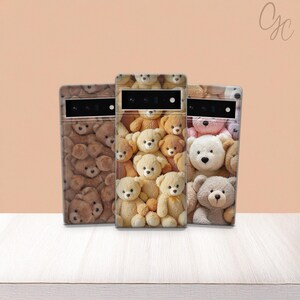 May include: Three phone cases with teddy bear designs. The cases feature a variety of teddy bears in shades of brown, tan, and white. The cases are displayed on a white surface against a peach-colored background.