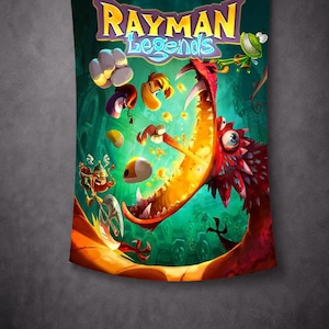 May include: A Rayman Legends tapestry featuring a vibrant, action-packed scene. The artwork showcases a large, red dragon with an open mouth, surrounded by colorful characters and the game's title. The background is a deep green, creating a dynamic visual.