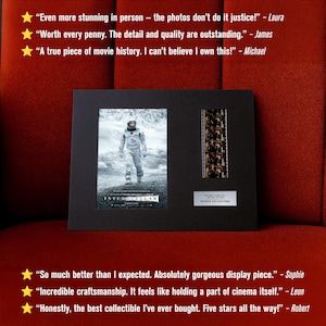 May include: A framed black display featuring a movie poster and film strip from the movie "Interstellar." The poster shows a figure in a spacesuit. The film strip is mounted vertically. The frame includes text: "Original Film Cell Limited Edition Private Collections."