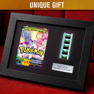 Può includere: Stampa incorniciata in nero con un poster del film Pokémon e una striscia di cella cinematografica. Il poster presenta Mewtwo contro Mew e Pikachu. La cornice include il testo "UNIQUE GIFT" in alto e "ORIGINAL FILM CELL LIMITED EDITION PRIVATE COLLECTIONS" in basso.