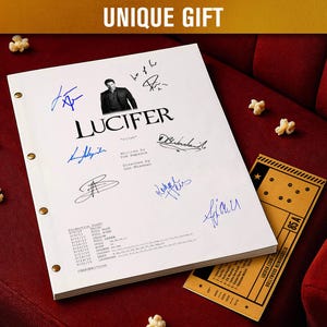 Può includere: Una sceneggiatura bianca intitolata "Lucifer" con più firme in inchiostro blu, un ritratto e un biglietto del cinema. La sceneggiatura è su una superficie di velluto rosso con popcorn sparsi. Il testo "UNIQUE GIFT" è in alto.
