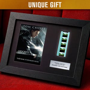 Puede incluir: Obra de arte enmarcada en negro con un cartel de la película "Minority Report" protagonizada por Tom Cruise. Incluye una tira de película y una placa que dice "Original Film Cell Limited Edition Private Collections". También es visible el texto "This Year Everybody Runs".