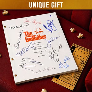 Puede incluir: Un guion blanco titulado "The Godfather" con múltiples firmas en tinta azul y negra. El guion está sobre una superficie de terciopelo rojo con palomitas de maíz y una entrada de cine vintage. El texto "UNIQUE GIFT" está en la parte superior.
