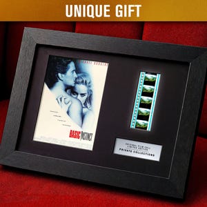 Może przedstawiać: Oprawione pamiątki filmowe z plakatem filmowym i paskiem filmowym z filmu "Basic Instinct". Czarna ramka zawiera plakat, komórki filmowe i tabliczkę z napisem "Original Film Cell Limited Edition Private Collections". U góry widnieje napis "UNIQUE GIFT".
