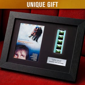 Puede incluir: Recuerdos de películas enmarcados con un póster y una tira de película de "Eternal Sunshine of the Spotless Mind". El marco negro incluye una celda de película y una placa que dice "Original Film Cell Limited Edition Private Collections."