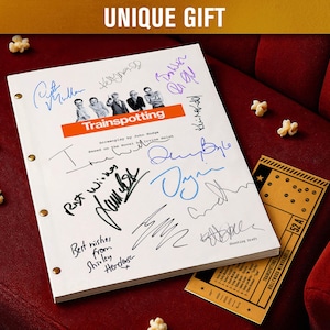 Puede incluir: Un guion de película de Trainspotting blanco con múltiples firmas, una barra de título naranja y una entrada de cine, sobre una superficie de terciopelo rojo. Las palabras "UNIQUE GIFT" están en la parte superior. Palomitas de maíz esparcidas.