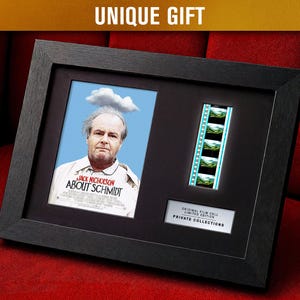 Könnte beinhalten: Gerahmte Filmerinnerungsstücke mit einem Porträt von Jack Nicholson aus "About Schmidt", einem Filmstreifen und dem Text "UNIQUE GIFT". Der schwarze Rahmen befindet sich auf einer roten Oberfläche. Die Filmzelle ist mit "ORIGINAL FILM CELL LIMITED EDITION PRIVATE COLLECTIONS" beschriftet.