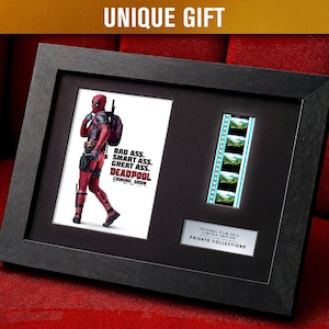 Può includere: Opera d'arte incorniciata in nero con un poster di Deadpool con la scritta "BAD ASS. SMART ASS. GREAT ASS. DEADPOOL COMING SOON." Include una striscia di pellicola e una targa "ORIGINAL FILM CELL LIMITED EDITION PRIVATE COLLECTIONS."