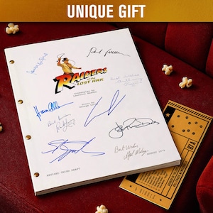Könnte beinhalten: Ein weißes Drehbuch mit dem Titel "Raiders of the Lost Ark" und mehreren Unterschriften, zusammen mit einer Kinokarte. Der Text "UNIQUE GIFT" steht oben. Popcorn ist auf einer roten Oberfläche verstreut.