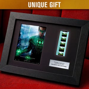 May include: Framed Green Lantern movie memorabilia. The black frame holds a movie poster, film strip, and a plaque that reads "ORIGINAL FILM CELL LIMITED EDITION PRIVATE COLLECTIONS". The image features a man in a green and black costume.