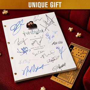 May include: A white script with multiple signatures, the title "Twilight", and the text "UNIQUE GIFT". A movie ticket and popcorn are also visible on a red surface.