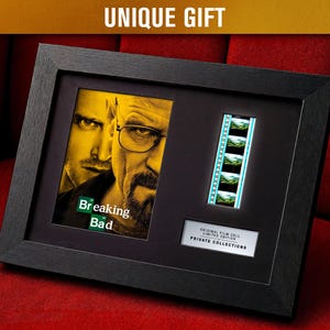 Peut inclure: Cadre noir contenant une affiche et une bande de film de la série télévisée "Breaking Bad". L'affiche montre deux hommes avec le titre de l'émission. La bande de film contient plusieurs images. Le cadre porte l'inscription "UNIQUE GIFT".