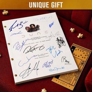 Op de afbeelding: Een wit script met handtekeningen, de titel "Dune" en een bioscoopkaartje liggen op een rode stoel. Het script heeft een foto van acteurs en wordt bij elkaar gehouden met messing sluitingen. Popcorn is verspreid rond het script en het kaartje. De tekst "UNIQUE GIFT" staat bovenaan.