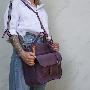 Stiff and roomy handbag made of beautiful leather in plum color