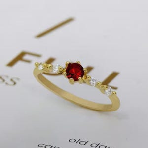 Delicato anello con zircone rosso rubino in rame placcato oro 14 carati, anello minimalista rotondo con gemma da indossare sopra altri anelli, gioiello geometrico leggero, ideale come regalo.