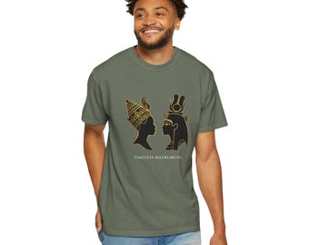 Puede incluir: Una camiseta de manga corta color verde oliva con un estampado gráfico de dos siluetas negras y doradas de figuras antiguas frente a frente. Debajo de las siluetas, el texto dice TIMELESS MATRIARCHS en una fuente blanca y clara.