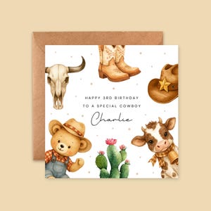 May include: A birthday card with a cowboy theme. The card features a bull skull, cowboy boots, a cowboy hat, a teddy bear, a cow, and a cactus. The text reads "Happy 3rd Birthday to a Special Cowboy" and "Charlie".