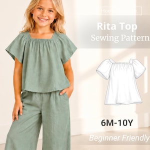 Puede incluir: Una blusa verde salvia con mangas cortas acampanadas y escote cuadrado, combinada con pantalones anchos a juego. La imagen incluye un dibujo lineal blanco del patrón de costura Rita Top, etiquetado 6M-10Y, para un nivel de principiante.