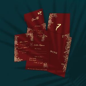 Peut inclure: Ensemble de papeterie de mariage bordeaux avec des motifs floraux dorés. Comprend des invitations, des cartons-réponse et des menus. Le mot "Charlotte" est écrit sur une carte, et le chiffre "7" sur une autre.