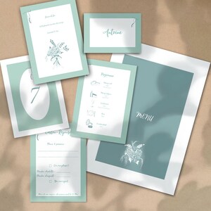 Peut inclure: Ensemble de papeterie de mariage dans les tons vert d'eau et blanc. L'ensemble comprend un menu, des cartons de table, des cartons de réponse et des cartons de numéros de table. Des illustrations florales et des polices manuscrites élégantes sont utilisées.