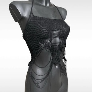 Può includere: Top nero all'americana realizzato in tessuto a maglia aperta. Il top presenta uno scollo quadrato e un design strappato con fili pendenti. Viene esposto su un manichino nero su sfondo bianco. Lo stile è audace e unico.