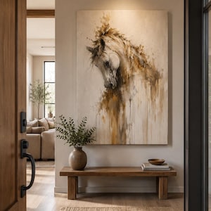 May include: A large rectangular wall art piece featuring an abstract painting of a horse head in shades of cream, beige, and brown. The artwork displays textured brushstrokes and paint drips, mounted on a plain wall above a wooden bench.