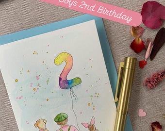 May include: A greeting card featuring a watercolour illustration of a person with a dog and a rabbit looking at a rainbow-coloured balloon shaped like the number 2. The card includes the text Little Boys 2nd Birthday in a pink banner.