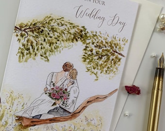 May include: A white greeting card with the text CONGRATULATIONS ON YOUR Wedding Day. The illustration features a couple sitting on a tree branch in a field, with the person on the left wearing a white dress and holding a bouquet of pink flowers.
