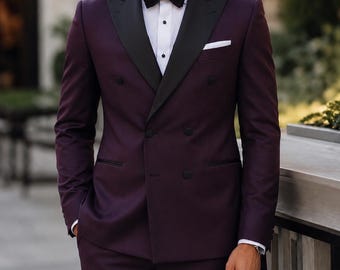 May include: A double-breasted deep purple tuxedo jacket with black peak lapels, paired with a crisp white dress shirt, a black bow tie, and a white pocket square. The jacket features dark buttons and a structured fit, creating a formal appearance.