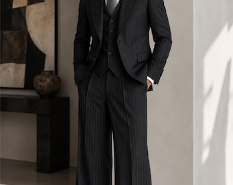 May include: A dark charcoal pinstripe three-piece suit consisting of a single-breasted blazer with wide lapels, a matching button-up vest, and wide-leg trousers. The suit is paired with a crisp white collared shirt and a solid grey necktie.