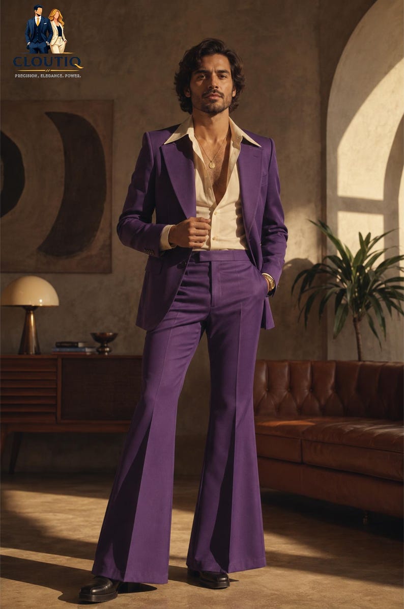 May include: A man in a purple suit with a cream-coloured shirt. The suit has flared trousers and a matching blazer. The man is wearing a gold necklace and black shoes. The background includes a brown leather sofa and a potted plant.