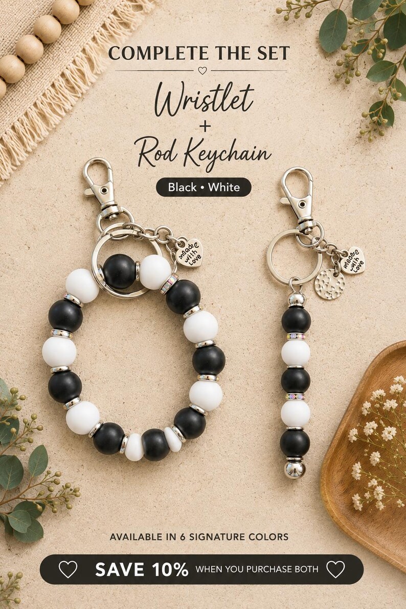 K&ouml;nnte beinhalten: Ein Set aus einem Armband-Schl&uuml;sselanh&auml;nger und einem Stab-Schl&uuml;sselanh&auml;nger mit abwechselnd mattschwarzen und wei&szlig;en Perlen sowie silberfarbenen Akzenten. Das Armband ist kreisf&ouml;rmig, der Stab-Anh&auml;nger linear. Beide haben einen Karabiner.