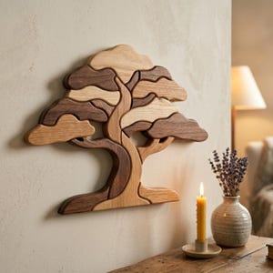 Può includere: Decorazione murale in legno a forma di albero, composta da pezzi di legno ad incastro nei toni del marrone e beige. L'albero presenta un tronco dettagliato, rami e una chioma folta. L'opera è fissata a una parete neutra, aggiungendo un elemento decorativo naturale.